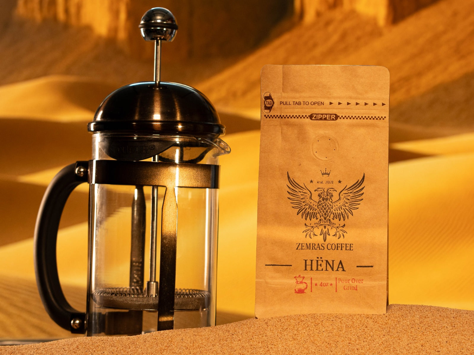 Hëna "Moon" decaf bag paired with a French press, highlighting the chemical-free Mountain Water Process and medium-dark roast.