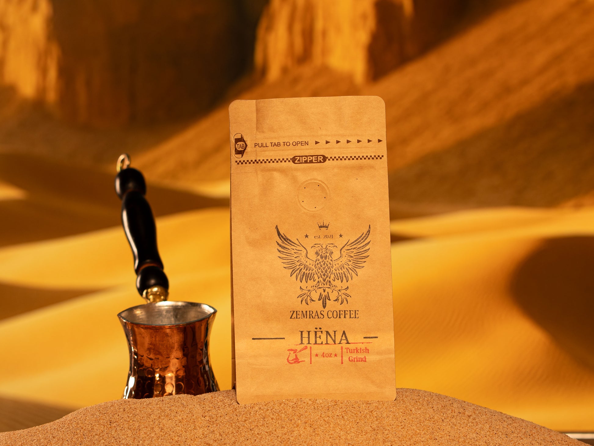 A bag of Hëna specialty decaf coffee alongside a traditional copper coffee pot, highlighting chemical-free Mountain Water Process beans.