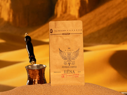 A bag of Hëna specialty decaf coffee alongside a traditional copper coffee pot, highlighting chemical-free Mountain Water Process beans.