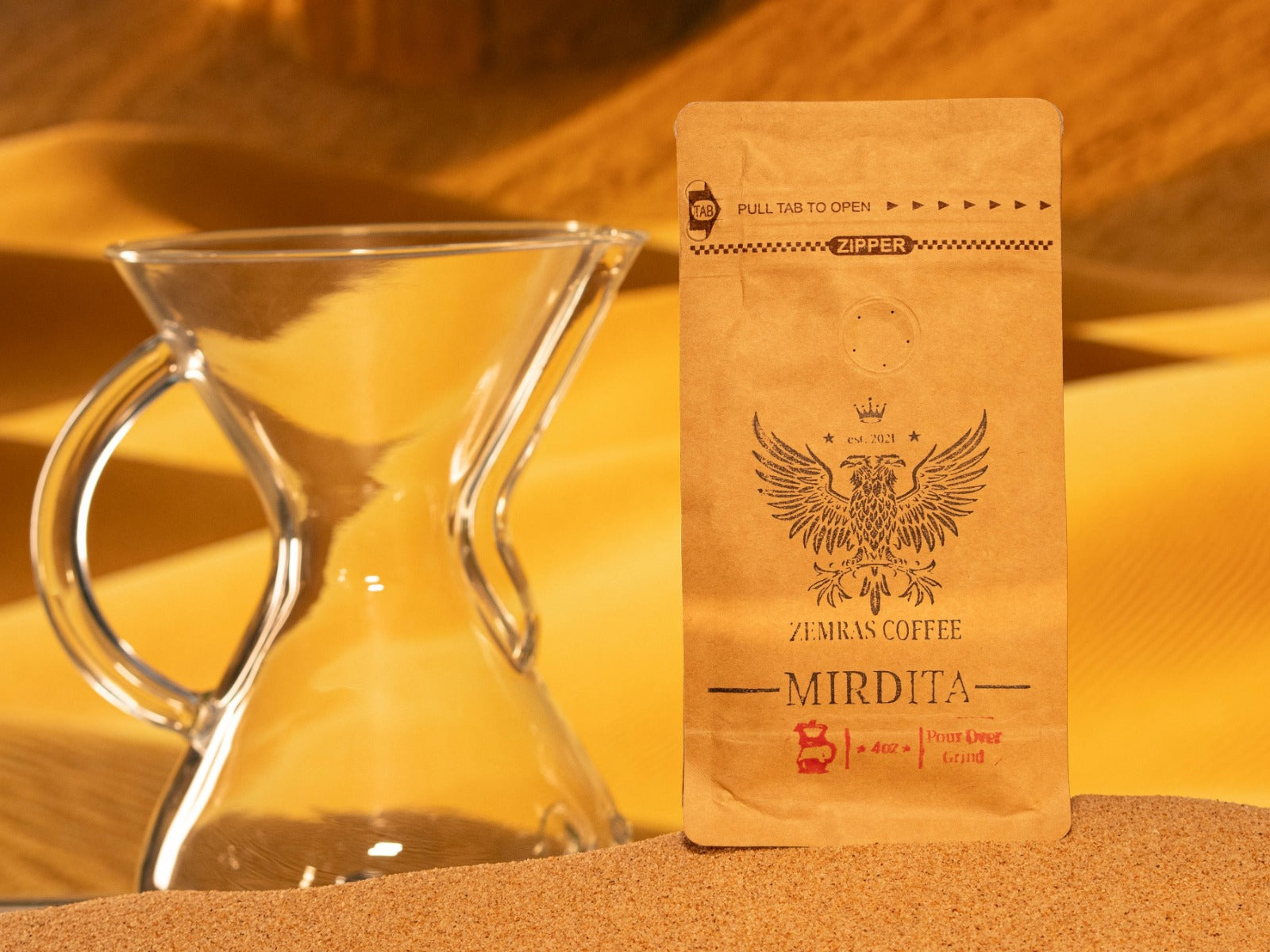 Mirdita Colombian dark roast coffee bag for pour-over, featuring a glass carafe and roasted with Enderly Coffee in Charlotte.