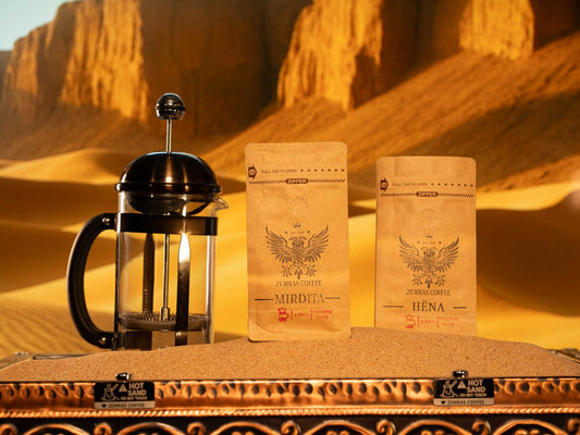 Mirdita and Hëna specialty coffee bags with a French press on a sand-brewing station, roasted in Charlotte by Enderly Coffee.