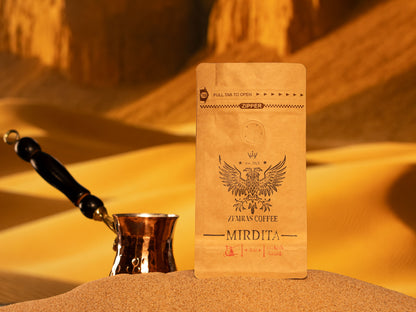Extra-fine Mirdita Turkish grind coffee bag on hot sand, perfect for authentic traditional brewing rituals.